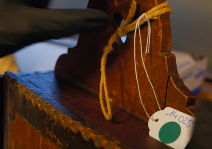 Vergroot de foto: Houten object met label en groene sticker