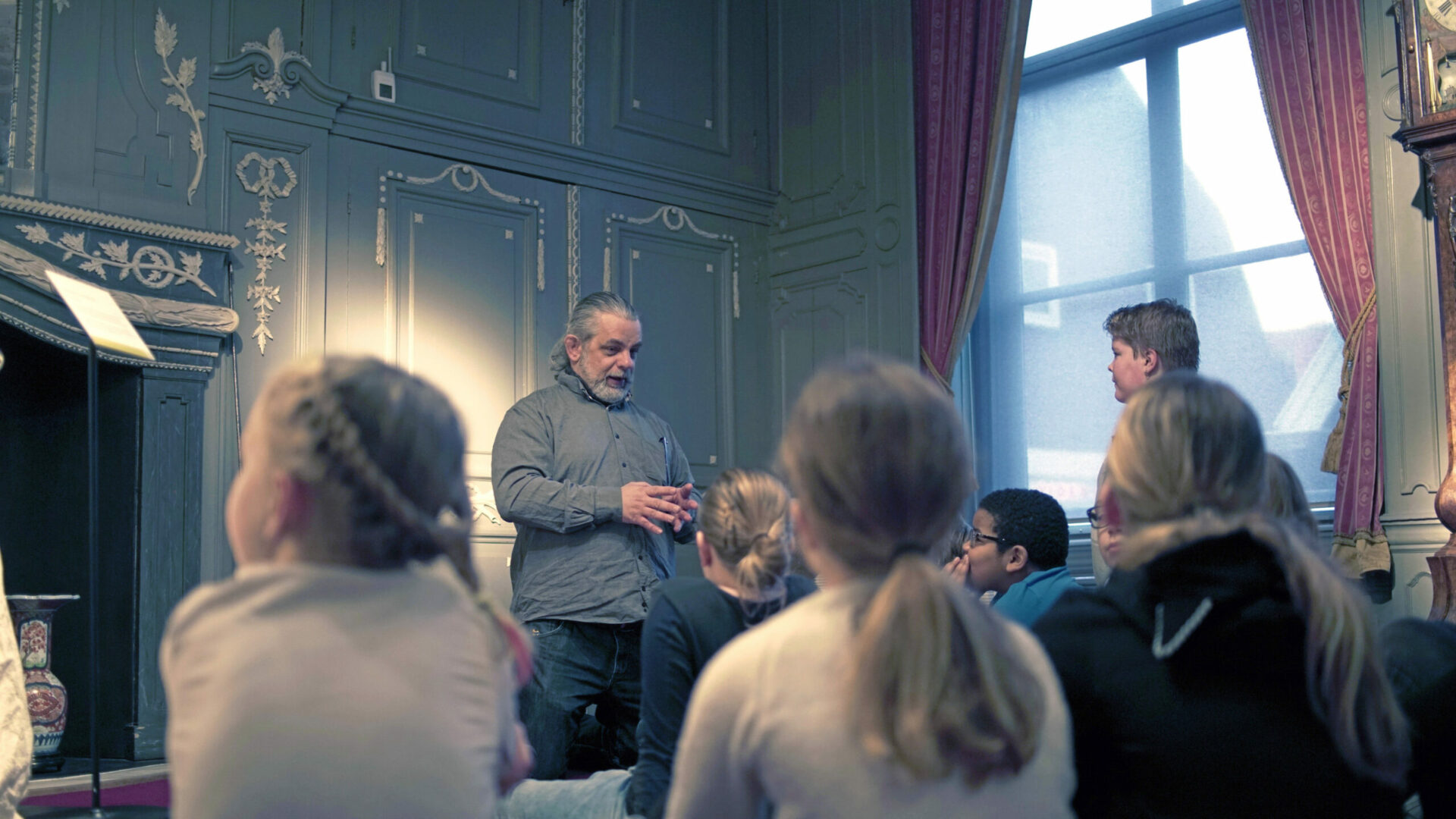 persoon geeft museumles aan meerdere kinderen