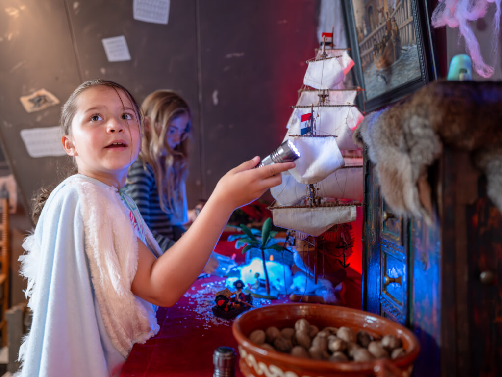 Kinderen met zaklamp in kamer met allerlei objecten