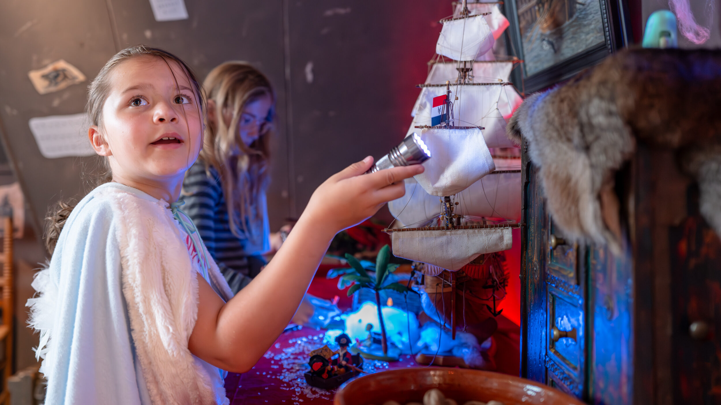 Kinderen met zaklamp in kamer met allerlei objecten