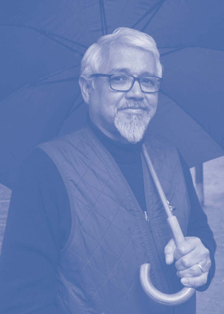 Portret Amitav Ghosh, met bril en paraplu