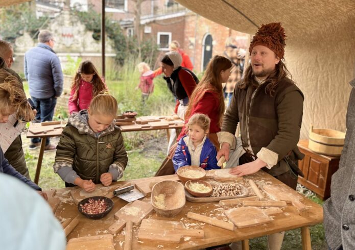 Personen bij tafel met houten plankjes en rollers maken flammkuchen