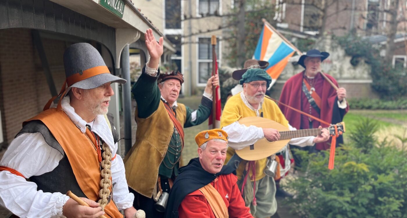 Muzikanten in 17e-eeuwse kleding met trommel en luit in binnentuin
