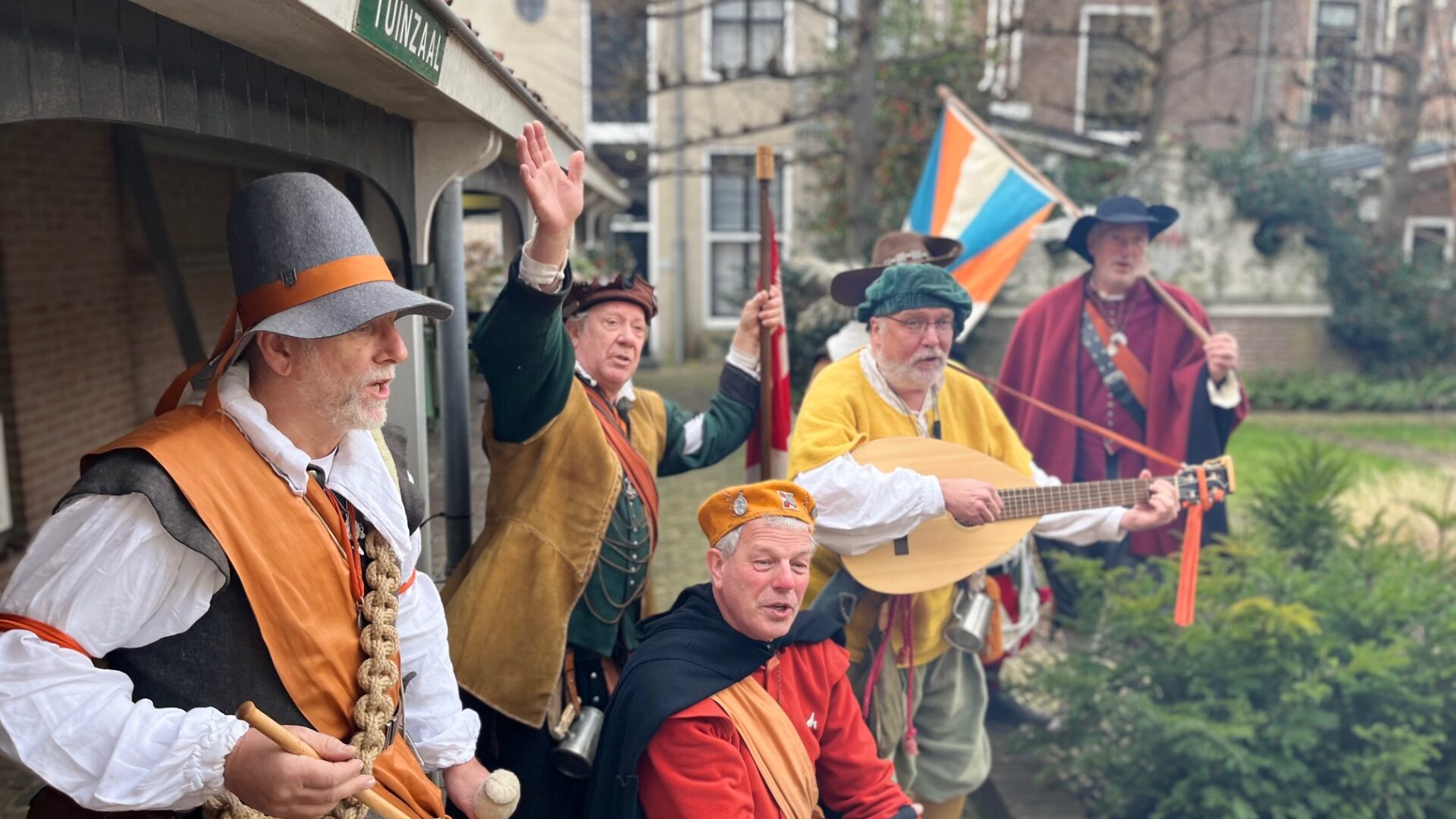 Muzikanten in 17e-eeuwse kleding met trommel en luit in binnentuin