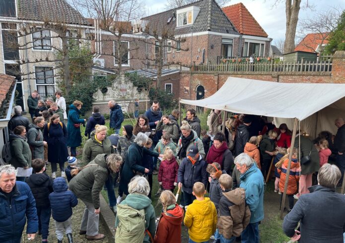 Grote groep mensen in binnentuin met kraam