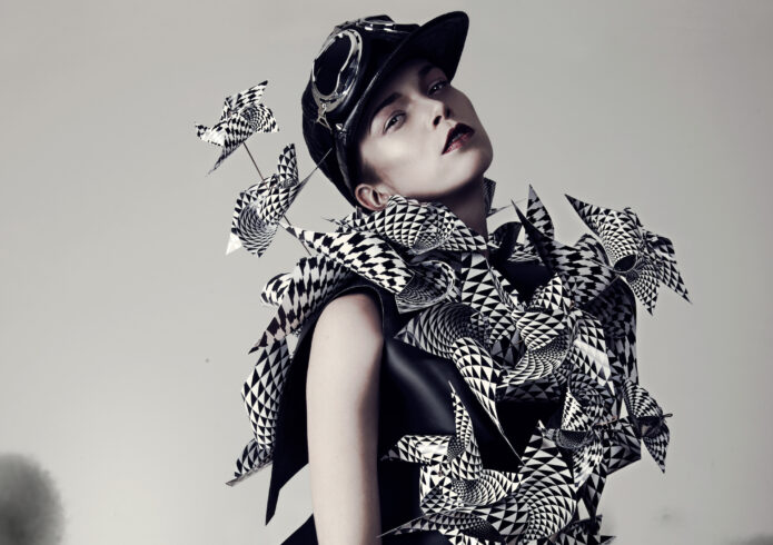 Persoon met wit en zwart kostuum, petje en gestreepte kousen